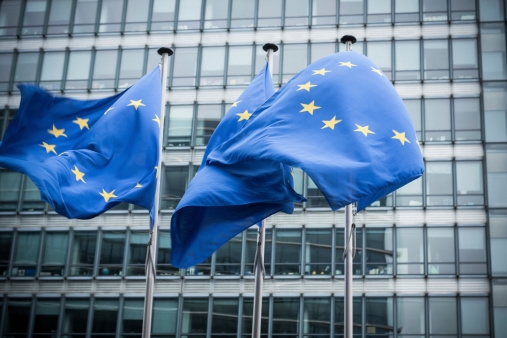 "European flags in front of the European Commission headquarters in Brussels, Belgium. ( Motion Blurred on flags)"